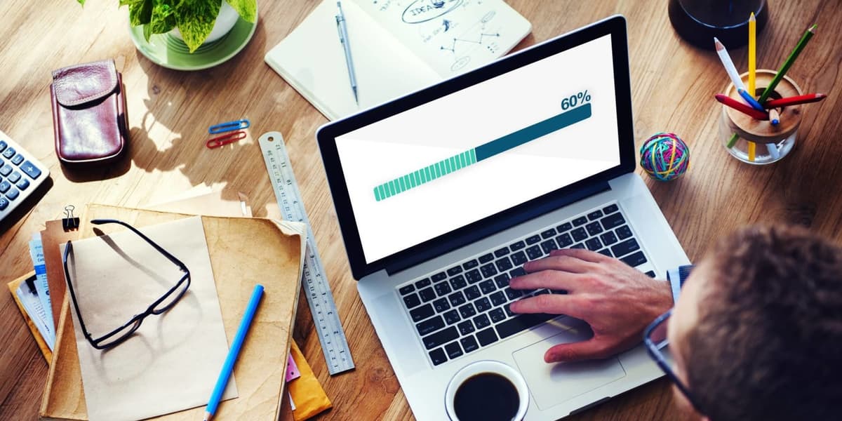 Een laptop van bovenaf gezien, met bureauaccessoires er rommelig omheen