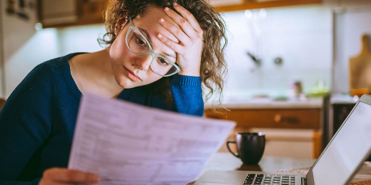 Vrouw kijkt bedenkelijk naar het papier in haar hand