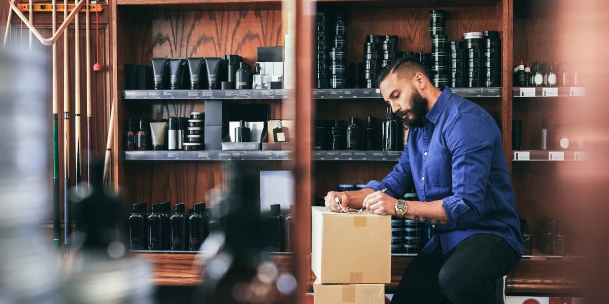 Barbier staat in zijn zaak en controleert een bestelling van producten